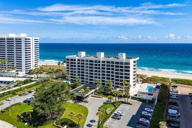 birds eye view of property featuring a water view and a beach view