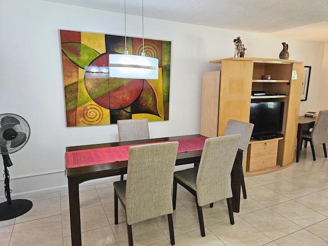 tiled dining space featuring a textured ceiling