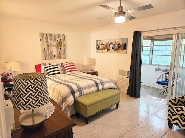 bedroom with light tile patterned floors, a textured ceiling, an AC wall unit, and ceiling fan