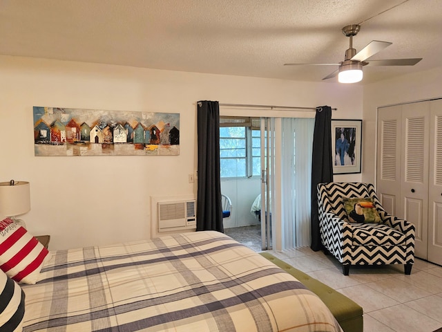 tiled bedroom with ceiling fan, a textured ceiling, and a closet