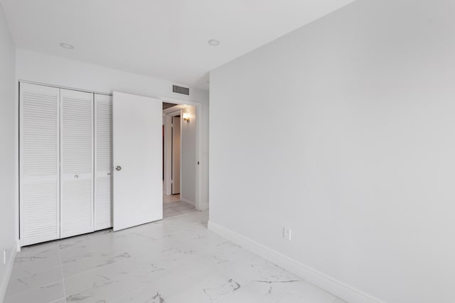 304 Wellington F, West Palm Beach, FL 33417 - unfurnished bedroom with light marble finish floors, baseboards, and a closet