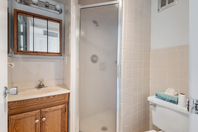 bathroom featuring tile walls, an enclosed shower, vanity, and toilet