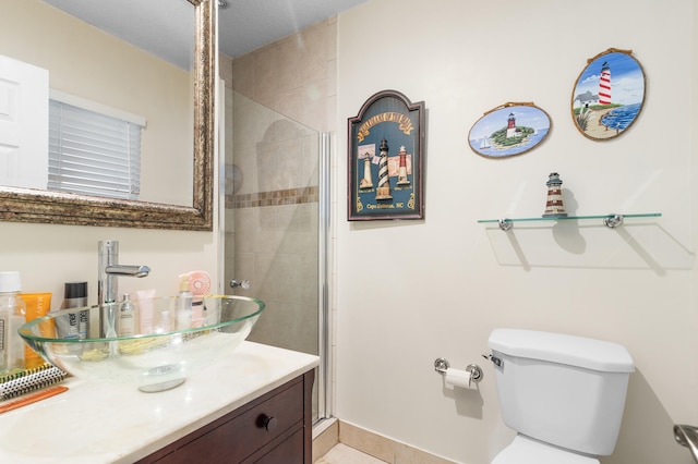 bathroom featuring toilet, a shower with door, and vanity