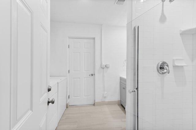 bathroom featuring tiled shower and hardwood / wood-style flooring