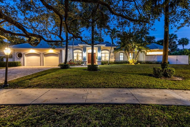 single story home with a garage and a front lawn