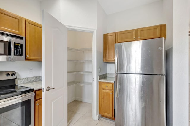 kitchen featuring appliances with stainless steel finishes and light tile patterned floors