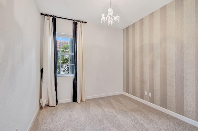 empty room with a notable chandelier and carpet floors