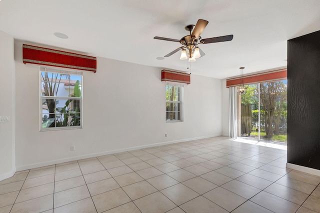 tiled empty room with ceiling fan and a wealth of natural light