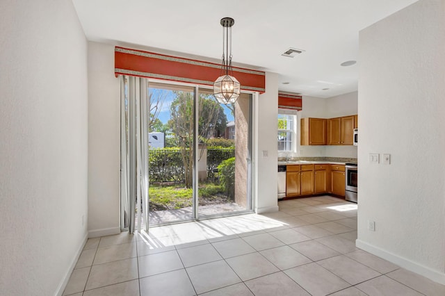 unfurnished dining area with light tile patterned floors and sink