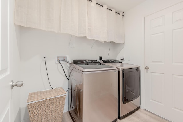 laundry area featuring washer and dryer and light wood-type flooring