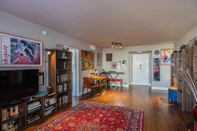 living room featuring dark hardwood / wood-style floors and a textured ceiling