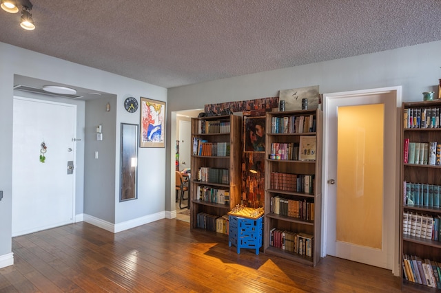 miscellaneous room with dark hardwood / wood-style floors and a textured ceiling