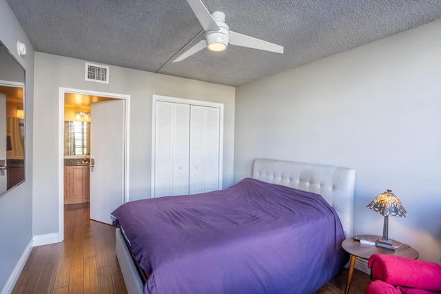 bedroom featuring dark hardwood / wood-style flooring, ceiling fan, a closet, and a textured ceiling