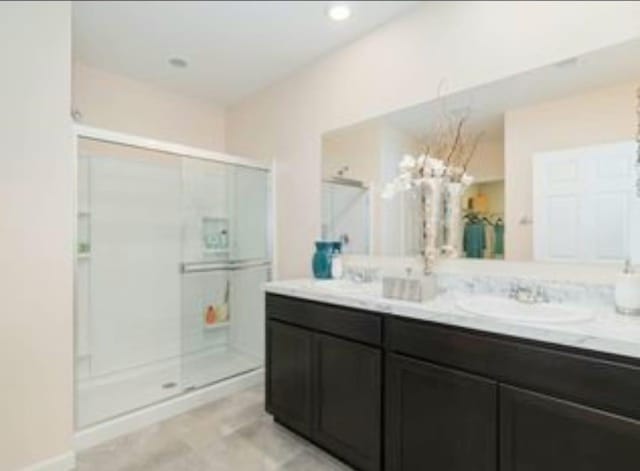 bathroom featuring vanity and a shower with door