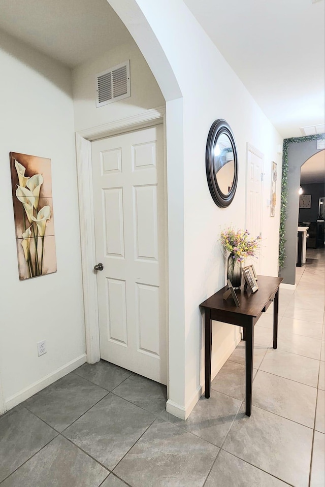 hall with tile patterned floors