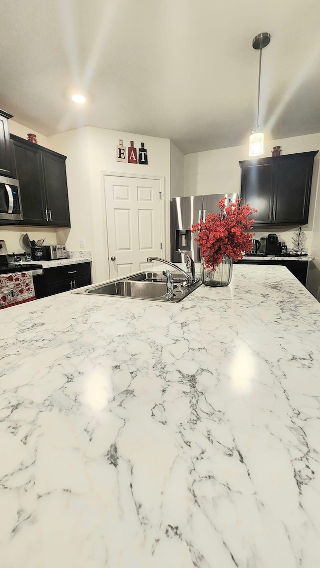 kitchen featuring appliances with stainless steel finishes, sink, and hanging light fixtures