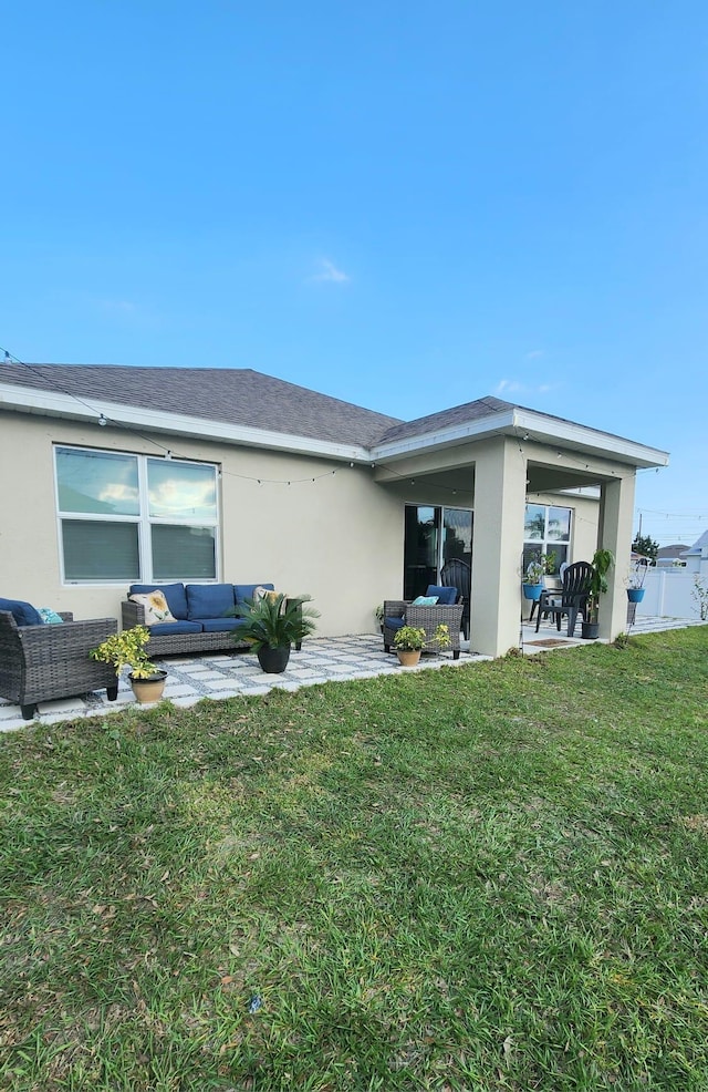 back of property featuring a yard, an outdoor hangout area, and a patio area