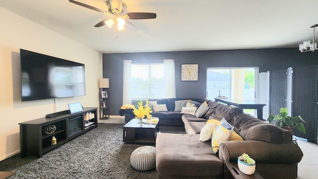 carpeted living room featuring ceiling fan with notable chandelier