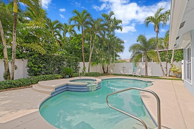 view of pool with a pool with connected hot tub, a patio area, and a fenced backyard