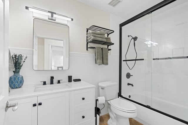 812 NW 26th St, Wilton Manors, FL 33311 - bathroom with toilet, vanity, enclosed tub / shower combo, tile walls, and wainscoting