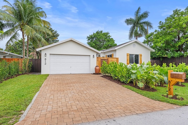 812 NW 26th St, Wilton Manors, FL 33311 - ranch-style home with stucco siding, decorative driveway, and an attached garage