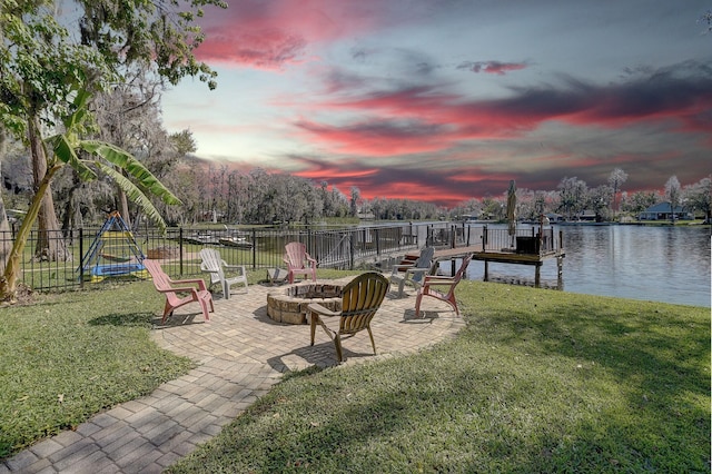 view of dock with an outdoor fire pit, a lawn, a patio, a water view, and fence