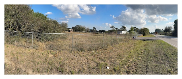 view of yard with a rural view and fence