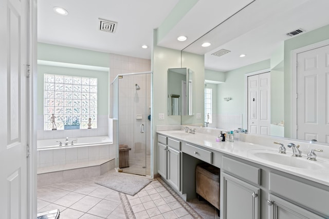 full bath featuring visible vents, a sink, a shower stall, and tile patterned floors