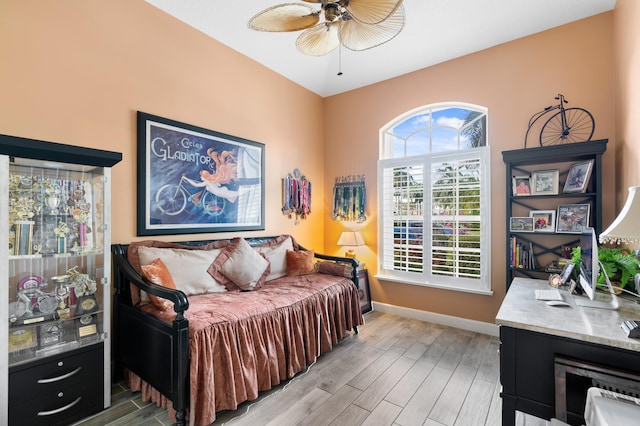 bedroom with light wood finished floors, ceiling fan, and baseboards