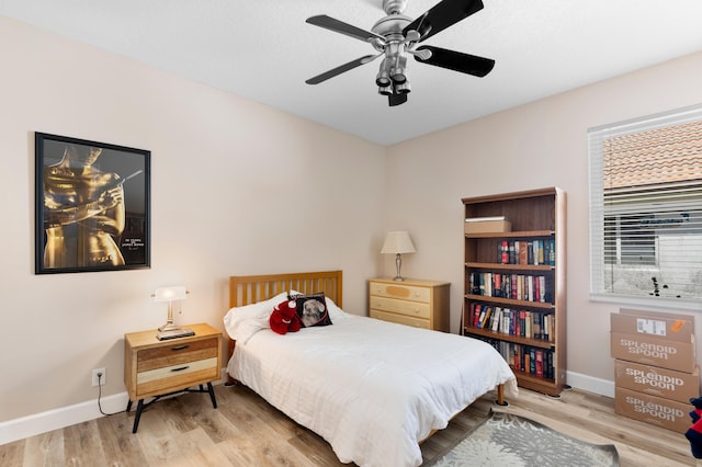 bedroom featuring a ceiling fan, baseboards, and wood finished floors