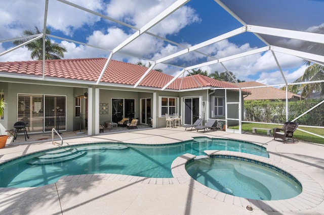 view of swimming pool with glass enclosure, a pool with connected hot tub, and a patio