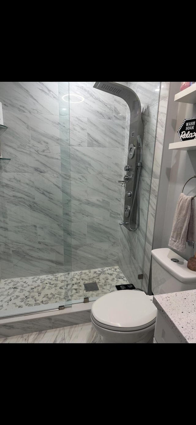 bathroom with toilet and tiled shower