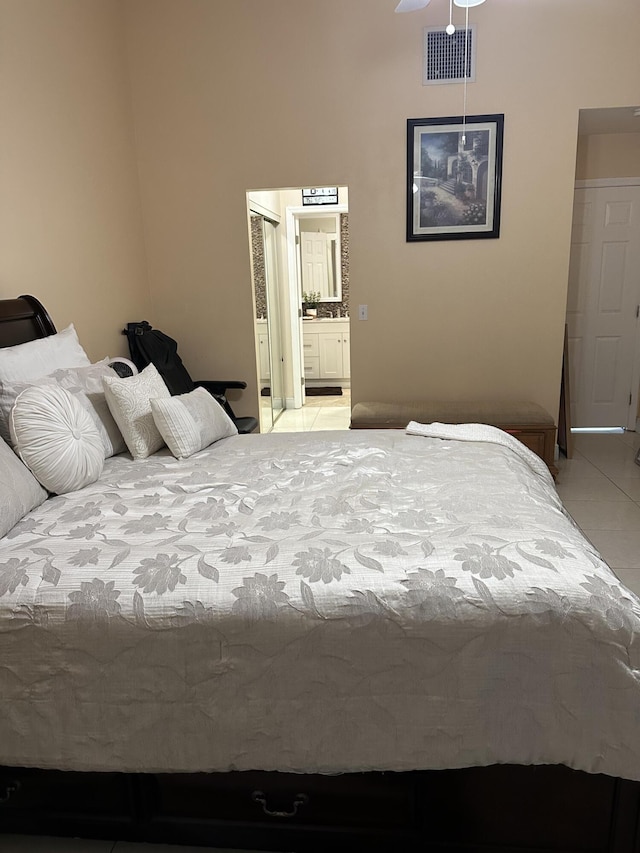 bedroom featuring ensuite bath, visible vents, a closet, and light tile patterned flooring