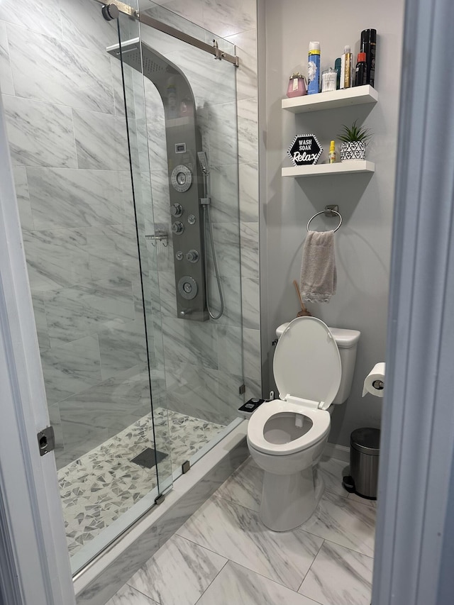 bathroom with marble finish floor, a stall shower, toilet, and baseboards