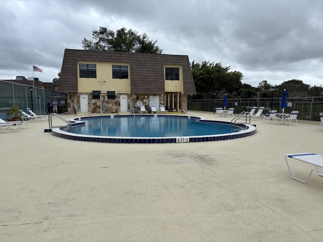 community pool featuring a patio area and fence