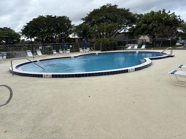 community pool featuring a patio area and fence