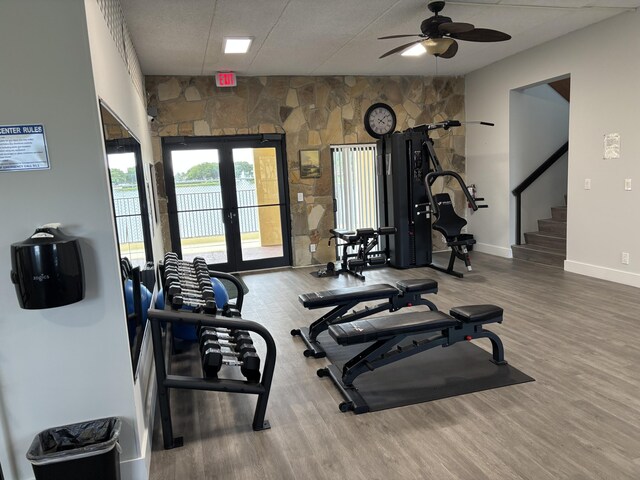 exercise room featuring a ceiling fan, french doors, baseboards, and wood finished floors