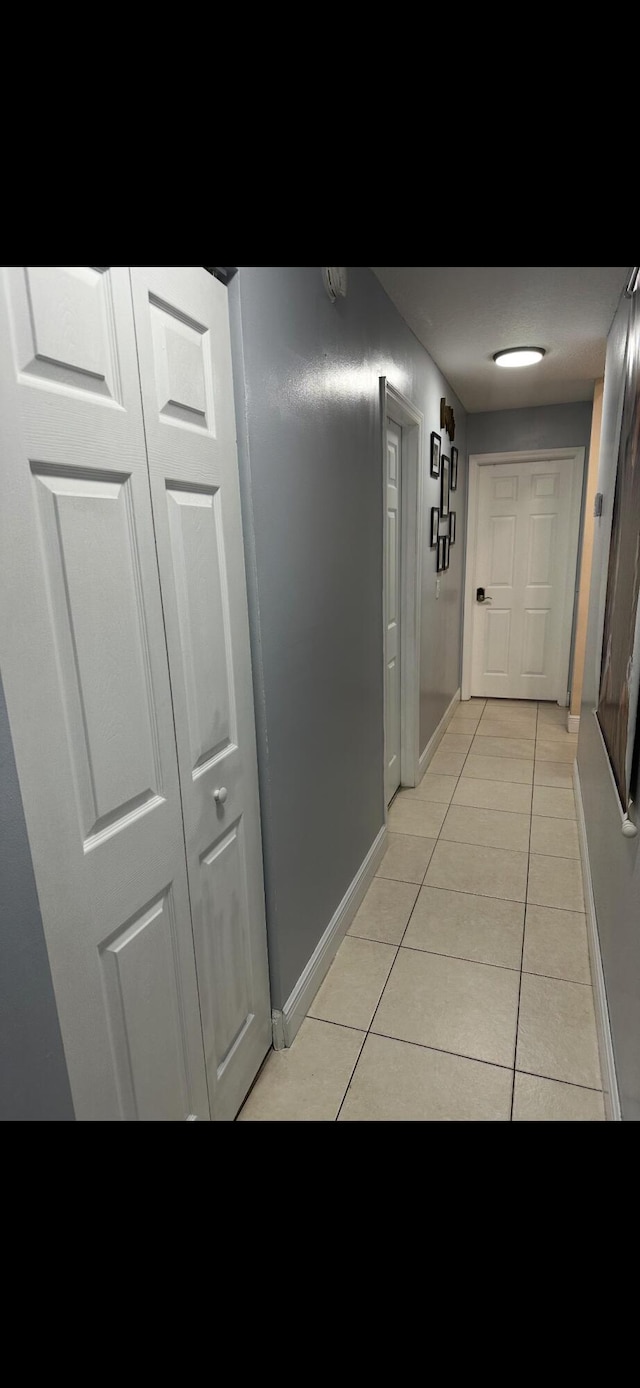 hall featuring light tile patterned flooring