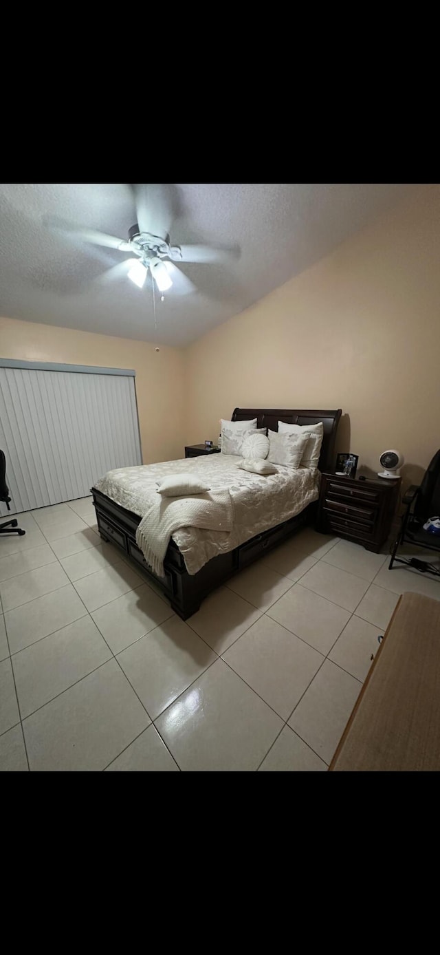 tiled bedroom featuring lofted ceiling and ceiling fan