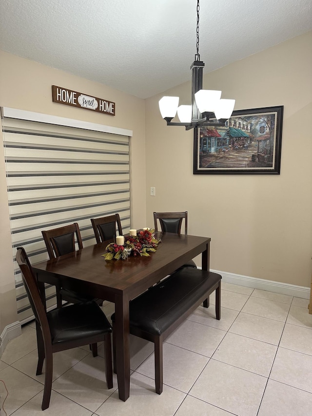 dining space featuring light tile patterned floors, baseboards, and an inviting chandelier