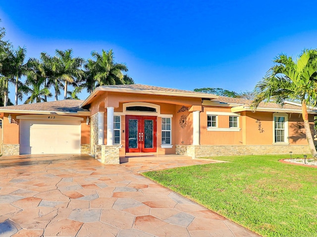 view of front facade featuring a garage, a front lawn, and french doors