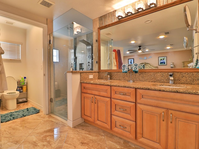 bathroom featuring ceiling fan, vanity, and a shower with door