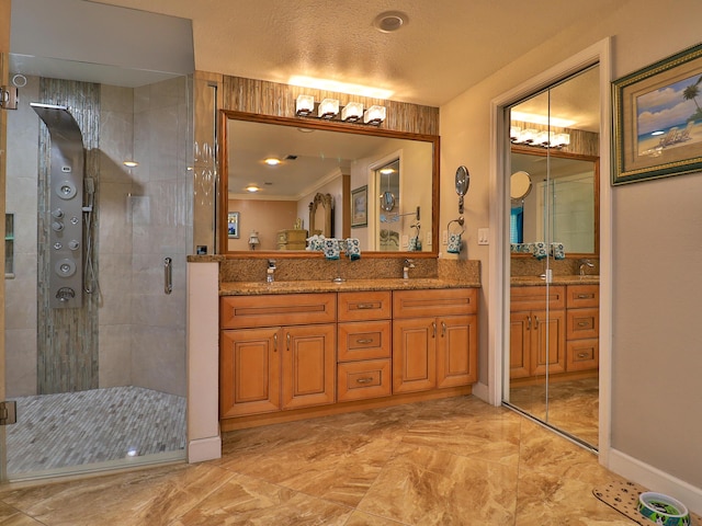 bathroom with vanity, an enclosed shower, and a textured ceiling