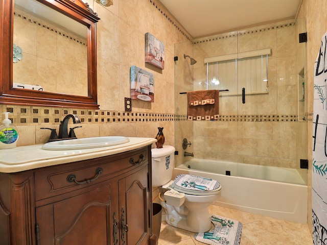 full bathroom with toilet, tiled shower / bath, tile walls, vanity, and tile patterned flooring