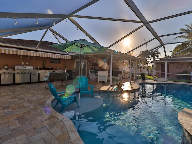 pool at dusk with area for grilling, a lanai, and a patio area