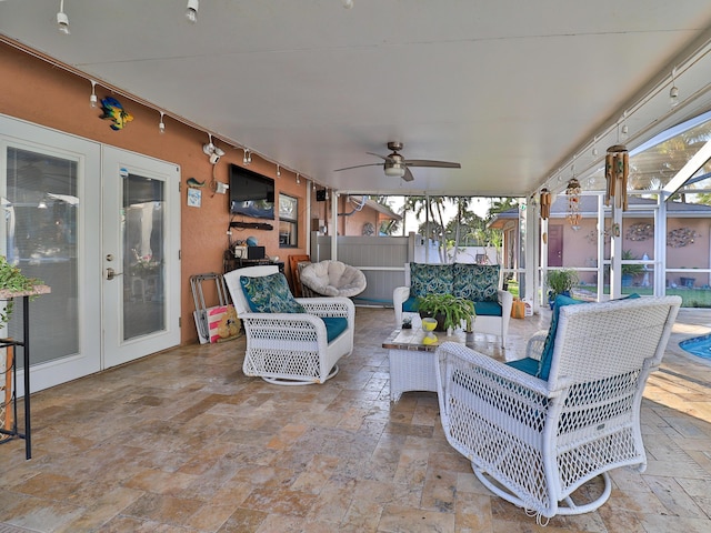 view of patio with an outdoor living space, a lanai, ceiling fan, and french doors