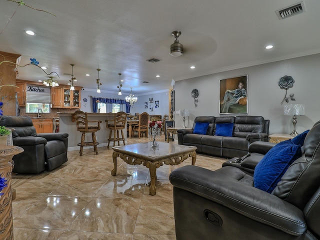 living room featuring crown molding, ceiling fan with notable chandelier, and sink