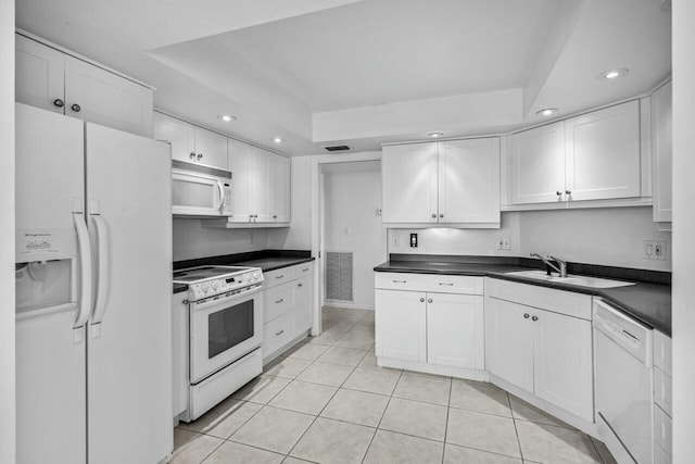 kitchen with white cabinets, white appliances, and a tray ceiling