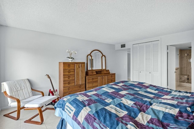 bedroom with ensuite bath, a closet, and a textured ceiling