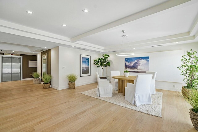 unfurnished dining area featuring beamed ceiling, elevator, and light wood-type flooring